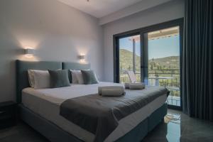 a bedroom with a large bed with a large window at Irida Studios and Suite in Paleokastritsa +46 photos
