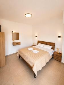a bedroom with a bed with two towels on it at Panagiotis' Seaside Apartment, Giorgos`House in Gialova