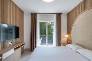 a hotel room with a bed and a television at Appartement Rosalia Delta Resort 741 in Ascona +101 photos
