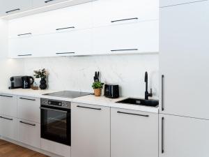 a white kitchen with white cabinets and appliances at Ahrensböker Residenz 7 in Stockelsdorf