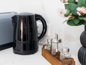 a black coffee pot on a counter next to a vase at Ahrensböker Residenz 7 in Stockelsdorf