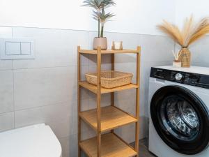 a wooden shelf next to a washing machine at Ahrensböker Residenz 7 in Stockelsdorf +20 photos