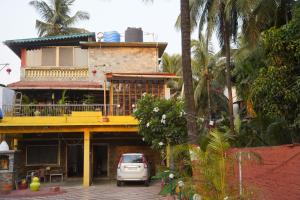 a white car parked in front of a building at Dr Vijeta's Wellness Retreat in Alībāg