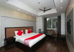 a bedroom with a large bed with red pillows at The Avenue Residency in Gurgaon