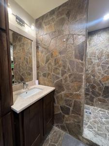 a bathroom with a sink and a stone wall at Apartman Trg in Šabac