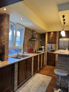 a large kitchen with wooden cabinets and a sink at Apartman Trg in Šabac