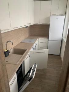 a kitchen with white cabinets and a sink and a refrigerator at Your Home 27 with parking in Myslava +11 photos