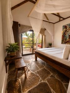 ein Schlafzimmer mit einem großen Bett und einem Tisch in der Unterkunft Beach Bohème in Paje + 104 Fotos