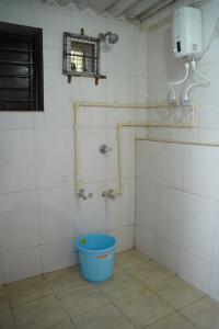a shower in a bathroom with a bucket in a room at Dr Vijeta's Wellness Retreat in Alībāg