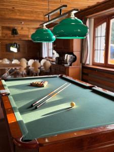 a pool table with cue balls and chopsticks on it at Colorado Riders Chalet in Crans-Montana