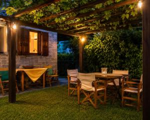a patio with a table and chairs under a pergola at Deja Blue in Mouresi