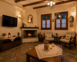 a living room with a fireplace and a tv at Deja Blue in Mouresi