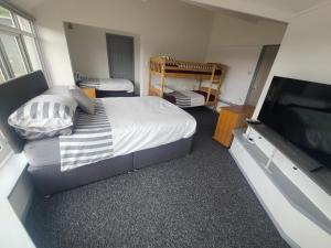 a bedroom with a bed and a flat screen tv at Oakwood Airport Accommodation in Lulsgate Bottom