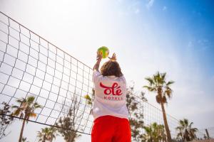 a person holding a frisbee over a net at Olé Tropical Tenerife Adults Only in Playa de las Americas
