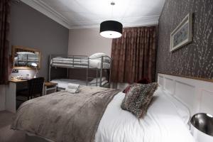 a bedroom with a bed and a desk and bunk beds at Parkwood Hotel in Stockton-on-Tees