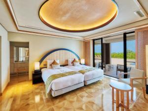 a bedroom with a large bed and a large window at Miyakojima Kurima Resort Seawood Hotel in Miyako-jima