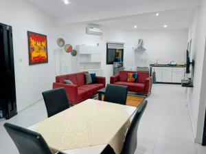 a living room with red couches and a table at Izuba APPART' HÔTEL in Ngaparou