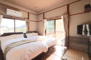 a bedroom with a large bed and a television at Kii no Matsushima in Kihokucho