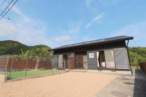 a small house with a fence in front of it at Kii no Matsushima in Kihokucho