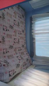 a bedroom with a bed and a wall with a window at blue caravan in Nea Potidaea