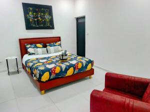a bedroom with a bed and a red chair at Izuba APPART' HÔTEL in Ngaparou