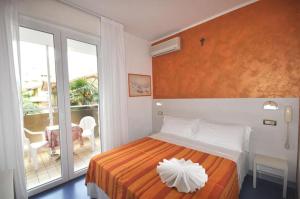 a bedroom with a bed with an orange and white blanket at Hotel Tre Rose New 2026 in Riccione