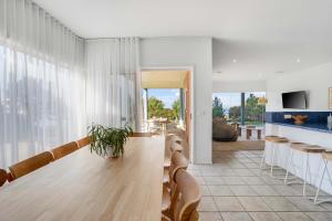 a living room with a wooden table and a kitchen at Ultimate Ocean Views - Pet Friendly in Bellbrae