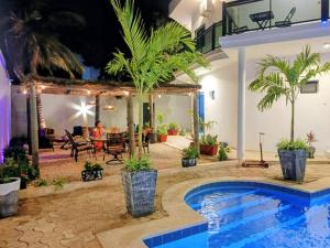 a villa with a swimming pool at night at Izuba APPART' HÔTEL in Ngaparou +5 photos