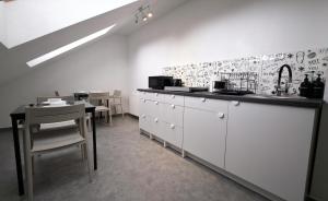 a white kitchen with a counter and a table at Villa Bianco in Międzyzdroje +40 photos