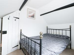 a bedroom with a black bed in a white room at Oar Cottage in Mablethorpe