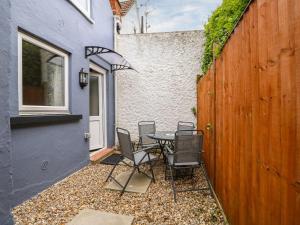 a patio with a table and chairs next to a fence at Oar Cottage in Mablethorpe