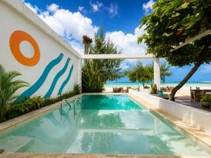 Ein Swimmingpool mit dem Meer im Hintergrund in der Unterkunft Beach Bohème in Paje