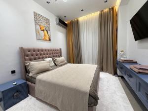a bedroom with a bed and a television in it at Gardence Residence Suite in Tashkent