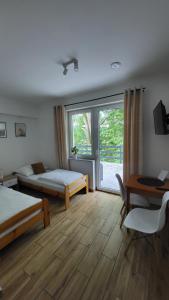 a bedroom with two beds and a desk and a window at Noclegi Na Gołębiówce in Wadowice