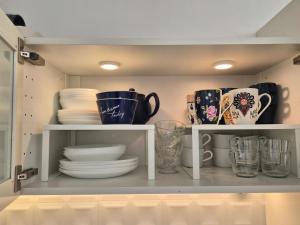 a cupboard filled with plates and cups and dishes at Mountain Szczyrk ApArt Bratków 10A in Szczyrk +74 photos