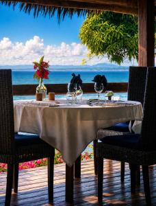 a table with wine glasses and a view of the ocean at Manga Soa Lodge in Fascène - Befefika