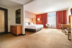 a hotel room with a bed and a table and chairs at Radisson Blu Hotel Krakow in Krakow +89 photos