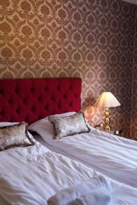 ein Schlafzimmer mit einem Bett mit rotem Kopfteil in der Unterkunft Centralhotellet Söderhamn in Söderhamn