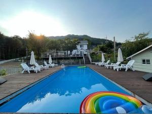 a swimming pool with a rainbow in the middle at Gapyeong Ohneulharu Spa Pension Pet friendly in Gapyeong