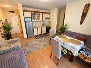 a living room with a table and a kitchen at Two-bedroom apartment with garden view in Sunny Beach