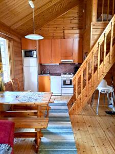 a kitchen and dining room with a table in a cabin at Holiday Home Marina in Tahkovuori +23 photos
