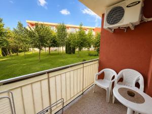 a balcony with a table and chairs and a window at Two-bedroom apartment with garden view in Sunny Beach