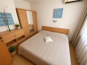 a bedroom with a bed with a pillow on it at Two-bedroom apartment with garden view in Sunny Beach