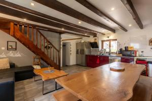 a kitchen and living room with a wooden table at Grange des 2 Cols - Jacuzzi - Jardin in Campan