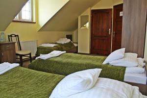 Habitación de hotel con 2 camas con sábanas verdes en Pod Strzechą, en Malawa