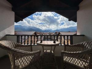 a balcony with three chairs and a table with a view at Marand Boutique Apartments in Bansko