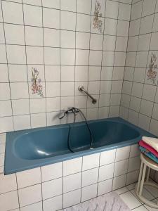 a blue tub in a bathroom with white tiles at Ferienwohnung Altes Rüsthaus in Ilz +11 photos
