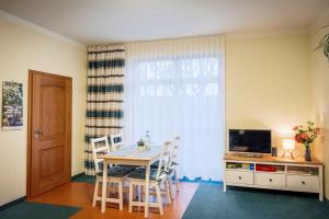 a dining room with a table with chairs and a television at Maisionette FEWO Sternchen in Heidenau