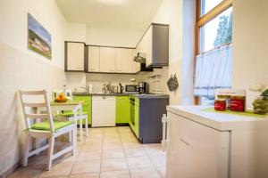 a kitchen with green and white cabinets and a table at Maisionette FEWO Sternchen in Heidenau +19 photos
