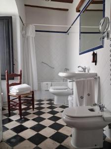 a bathroom with a sink and a toilet and a mirror at Hotel Ordóñez Sandoval in Úbeda